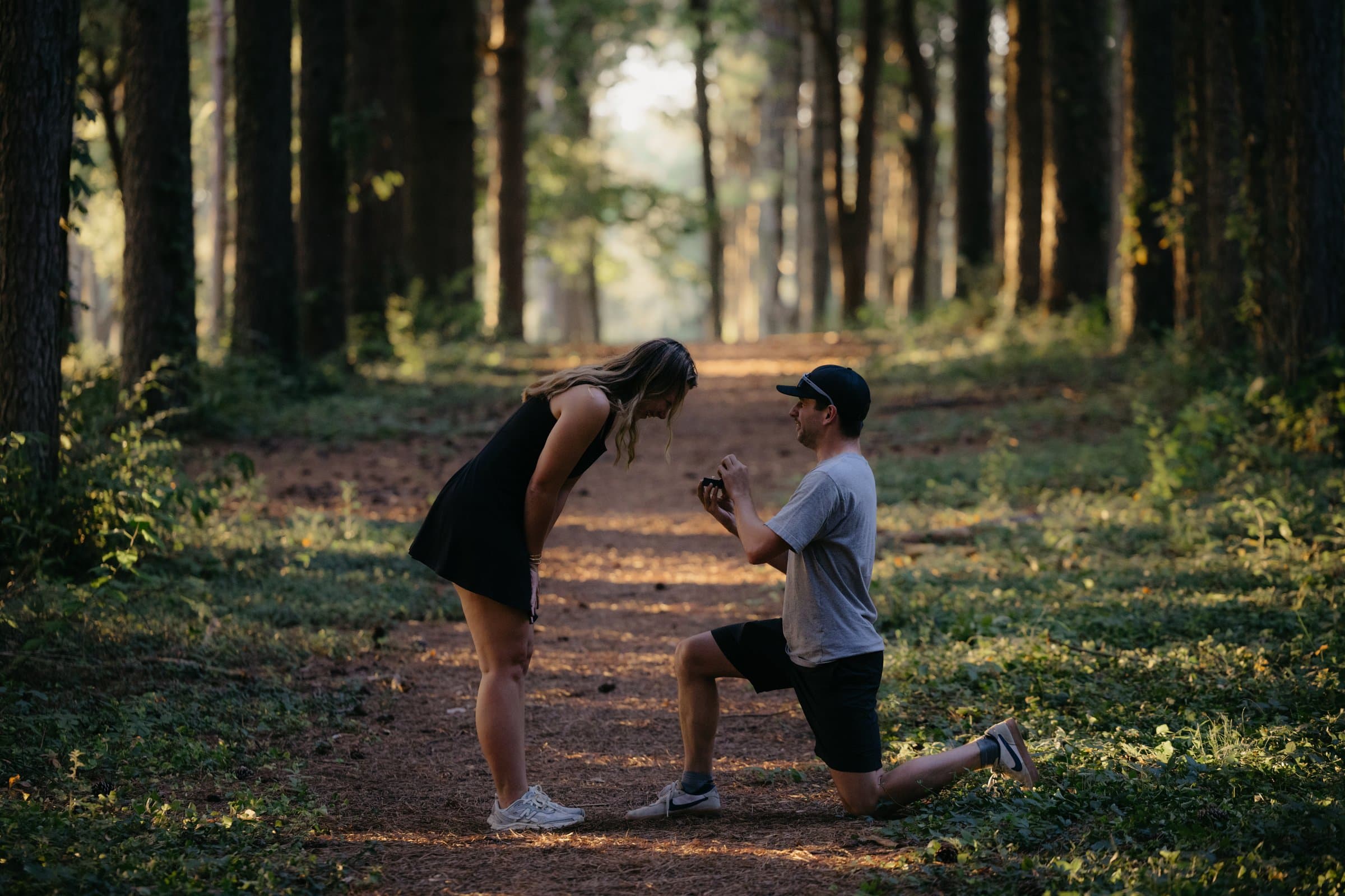 A proposal on one knee on a pine forest path in Lexington