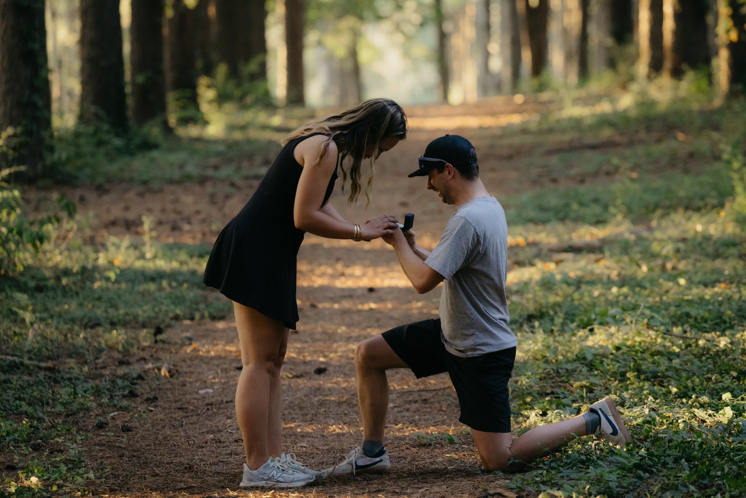 A ring going on her finger in a pine forest