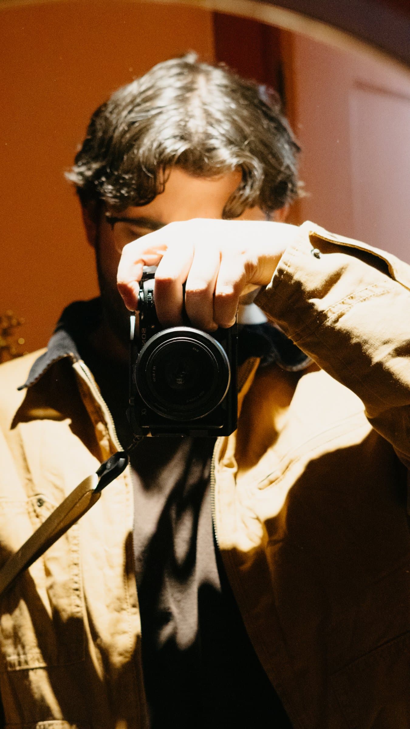 A photographer raising his camera in warm light