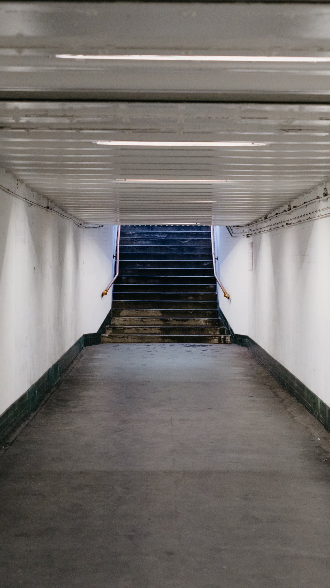 A tiled Underground tunnel leading to stairs