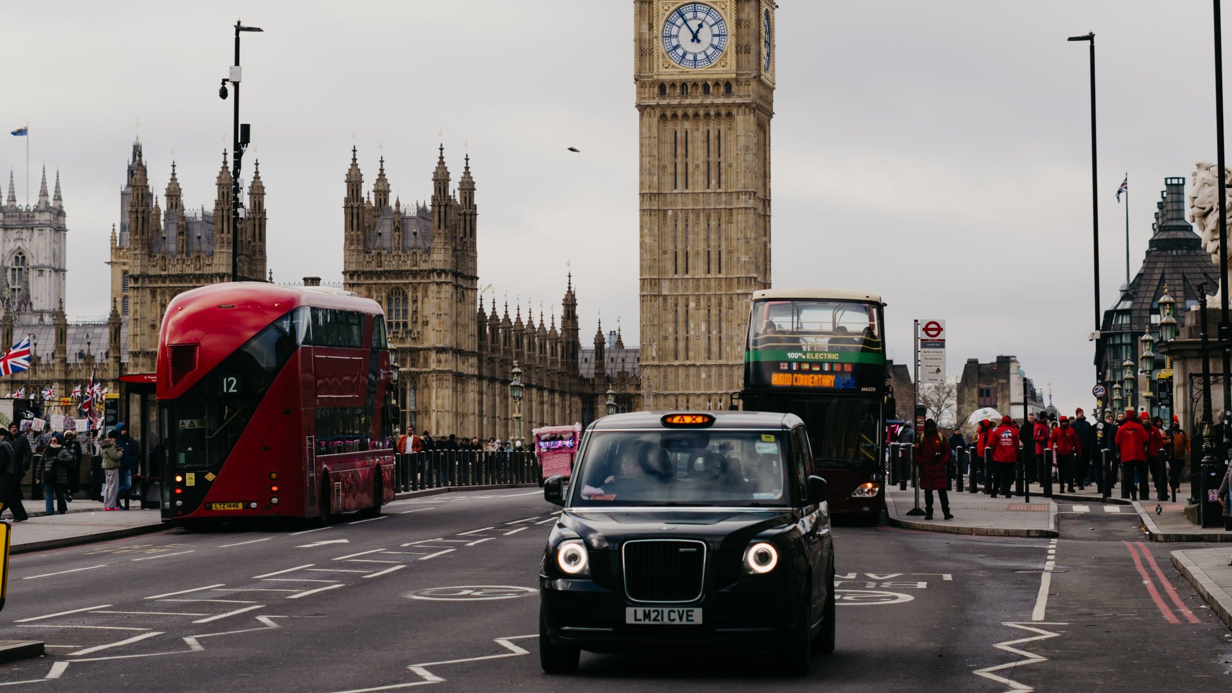 Big Ben with a red bus and a black cab on Westminster Bridge