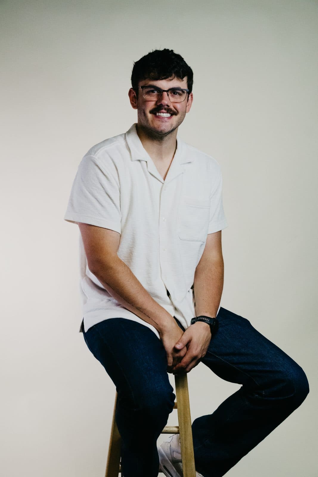 Nathaniel Bingham, seated on a stool, smiling